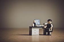 Lego-Männchen, welches verzeiftelt vor einem Schreibtisch sitzt