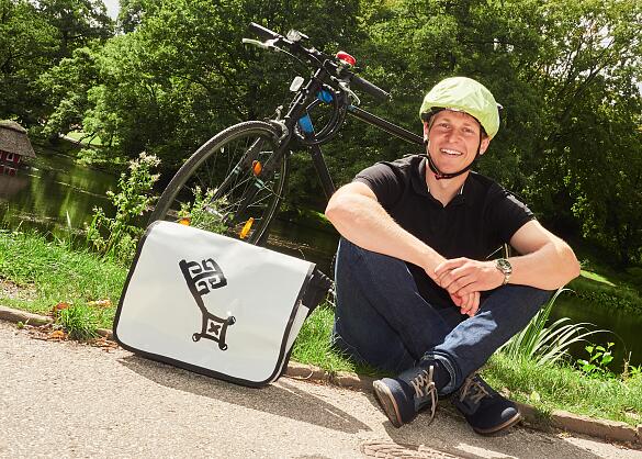 Ein Mitarbeiter des Aus- und Fortbildungszentrums sitzt vor seinem Fahrrad.